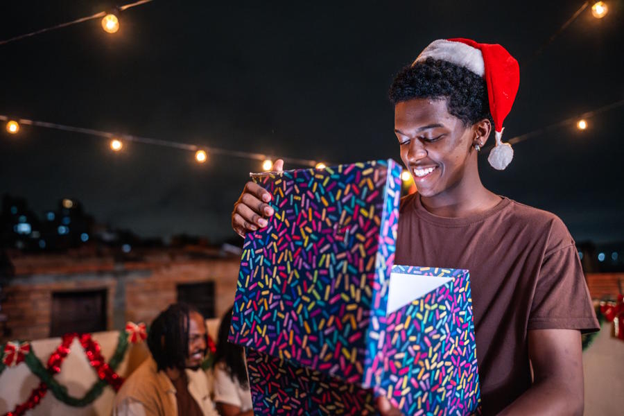 Teenage boy looking in a box and smiling on christmas