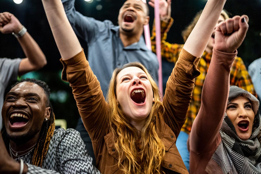 Teenagers enjoying themselves at a music event screaming and cheering