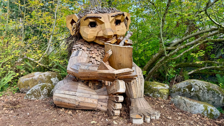 Thomas Dambo troll Wilde sketches in a wooden sketchbook at Northwest Trek